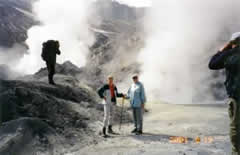 Hikers near steaming volcanic activity.